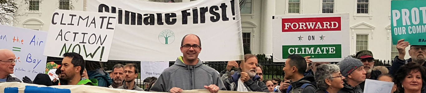 A photo of David Schneider participating in a climate protest.