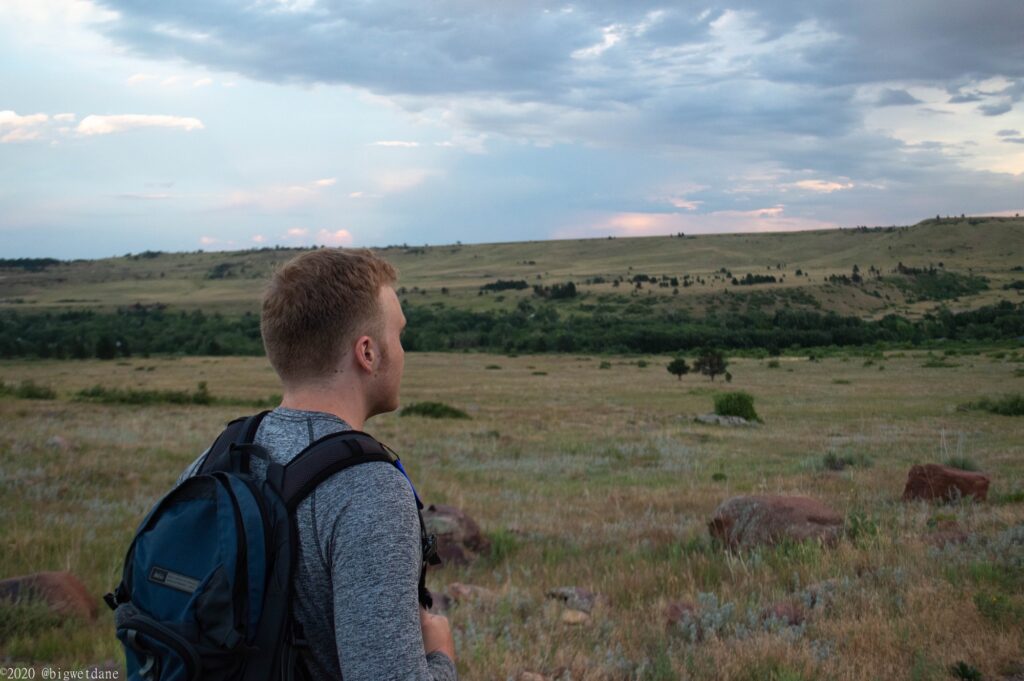 Noah standing in a field while he looks at the horizon