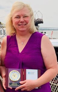 Betty Rockendorf holding her WHIMA educator award