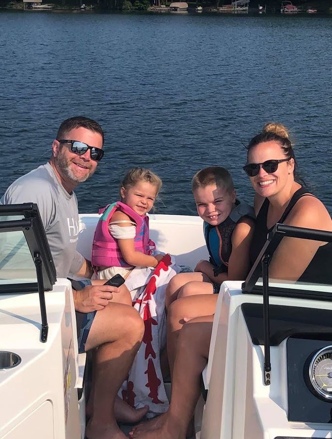 Mitch Frydrych with his young children and wife on a boat.