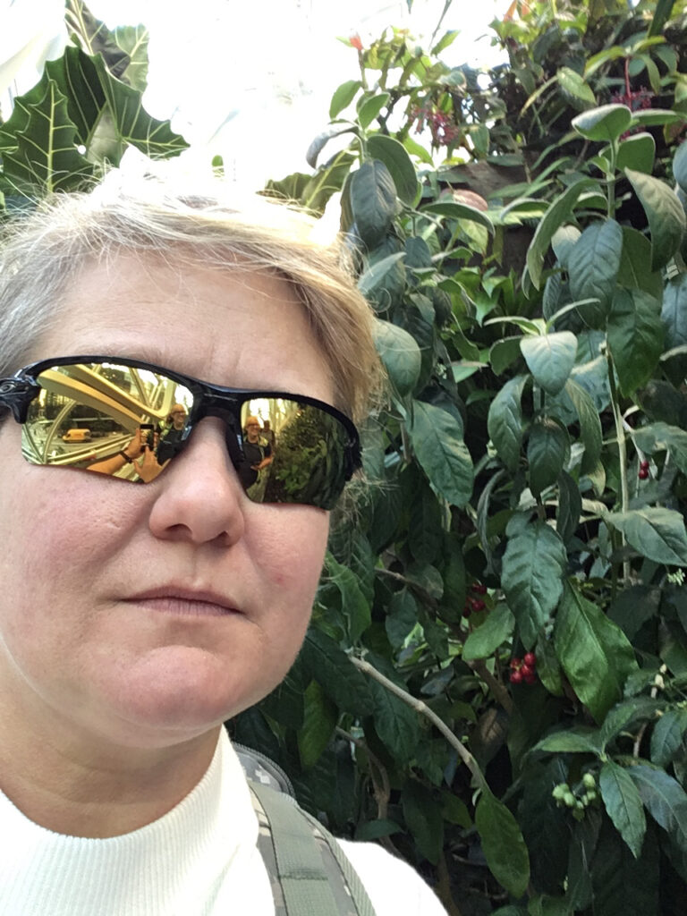 Sheilah Fondren on a nature hike with greenery behind her.