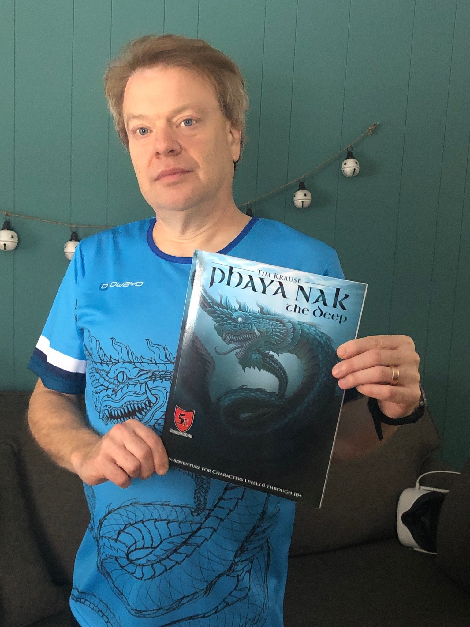 Tim holding a copy of Phaya Nak, a module he created for Dungeons & Dragons.