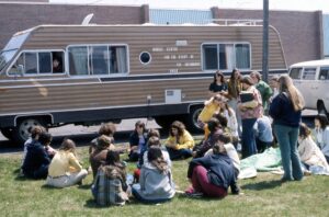 photo of a vintage motorhome, dubbed the 'Eco Van' with students at UW-Green Bay