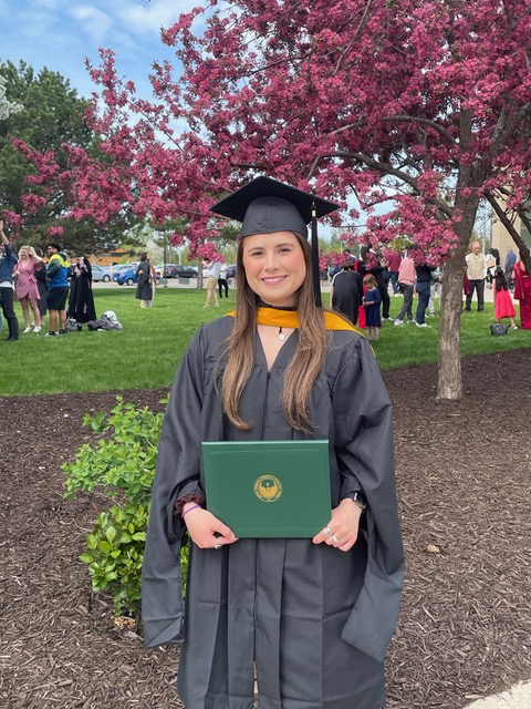 Lauren Fortin with her cap, gown, and diploma after graduating from UW-Green Bay