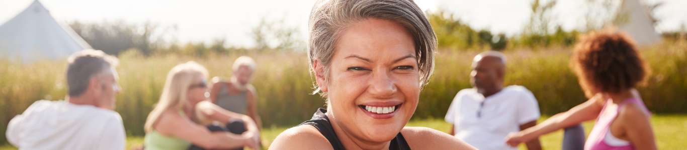 Portrait Of Mature Woman On Outdoor Yoga Retreat With Friends for Health and Wellness Management