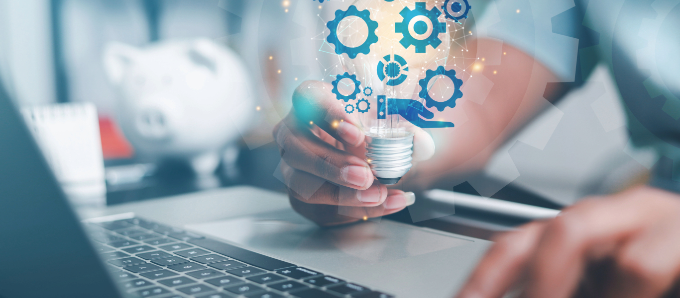 person typing on computer keyboard while holding a lightbulb with abstract images of information technology