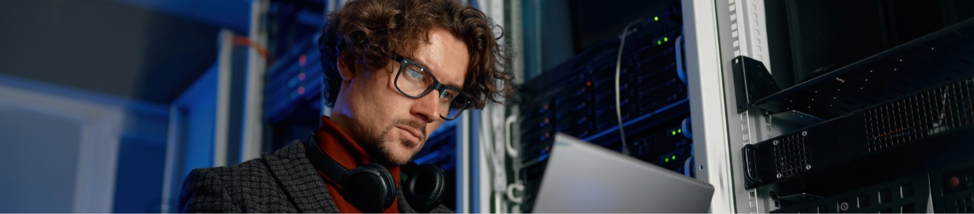 IT manager working on a laptop in a server room