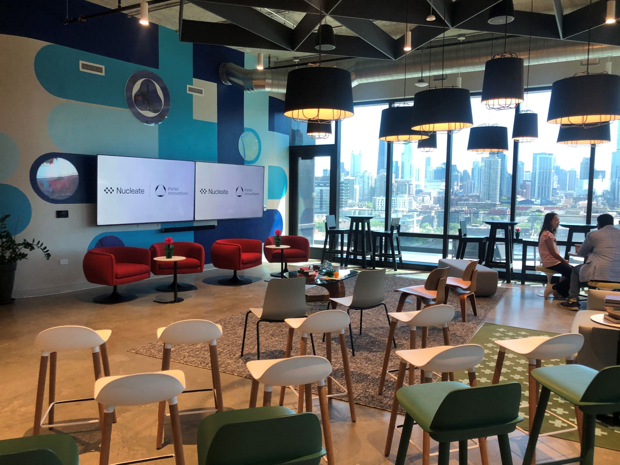 Rows of chairs fill an office space as the Chicago skyline can be seen through the windows. 