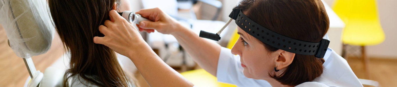 nurse checking patient's ear with otoscope